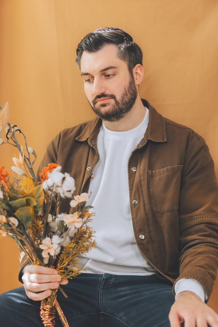 A fashion portrait holding a bouquet against warm tones