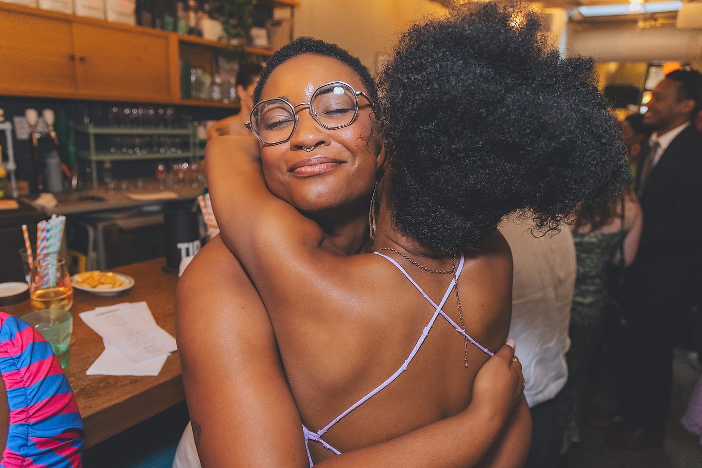 Brides share a tender embrace at their Washington DC bar wedding reception