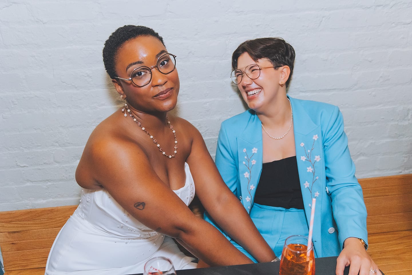 Arika and Madeline smile together at their Washington DC restaurant wedding reception