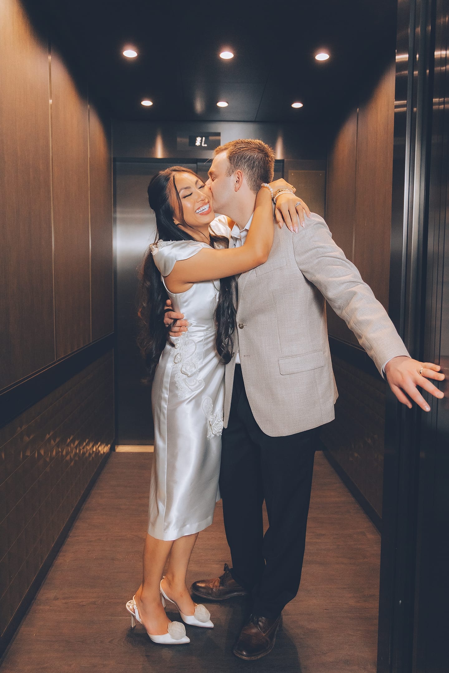 Bride and groom embrace in an elevator at their modern Washington DC wedding