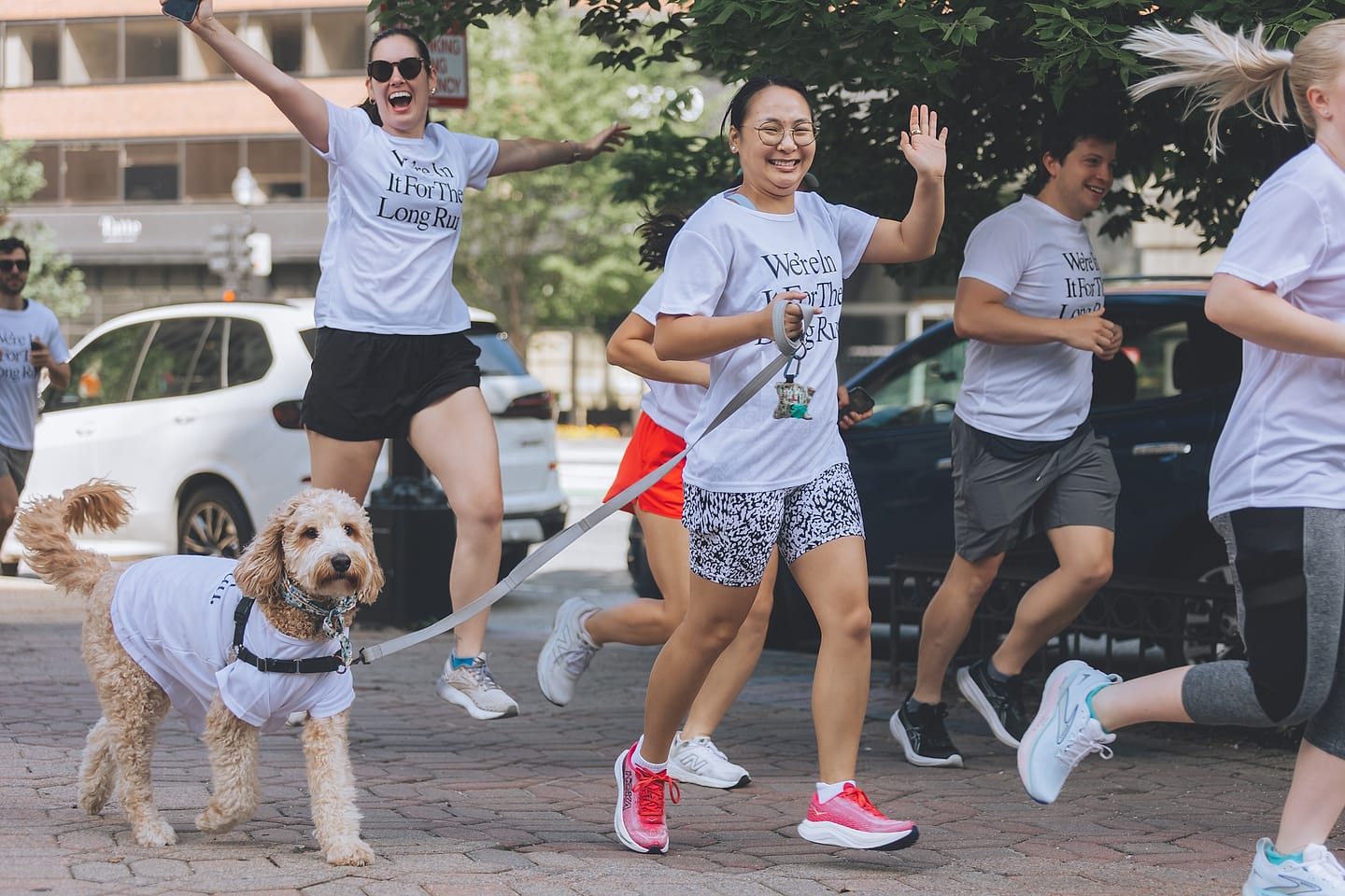 Guests and a dog run in matching tees at a Washington DC wedding-weekend fun run