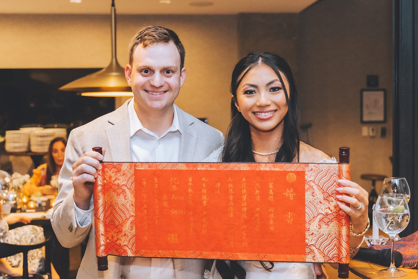 Jasmine and Aaron hold a traditional red wedding scroll at their Washington DC reception