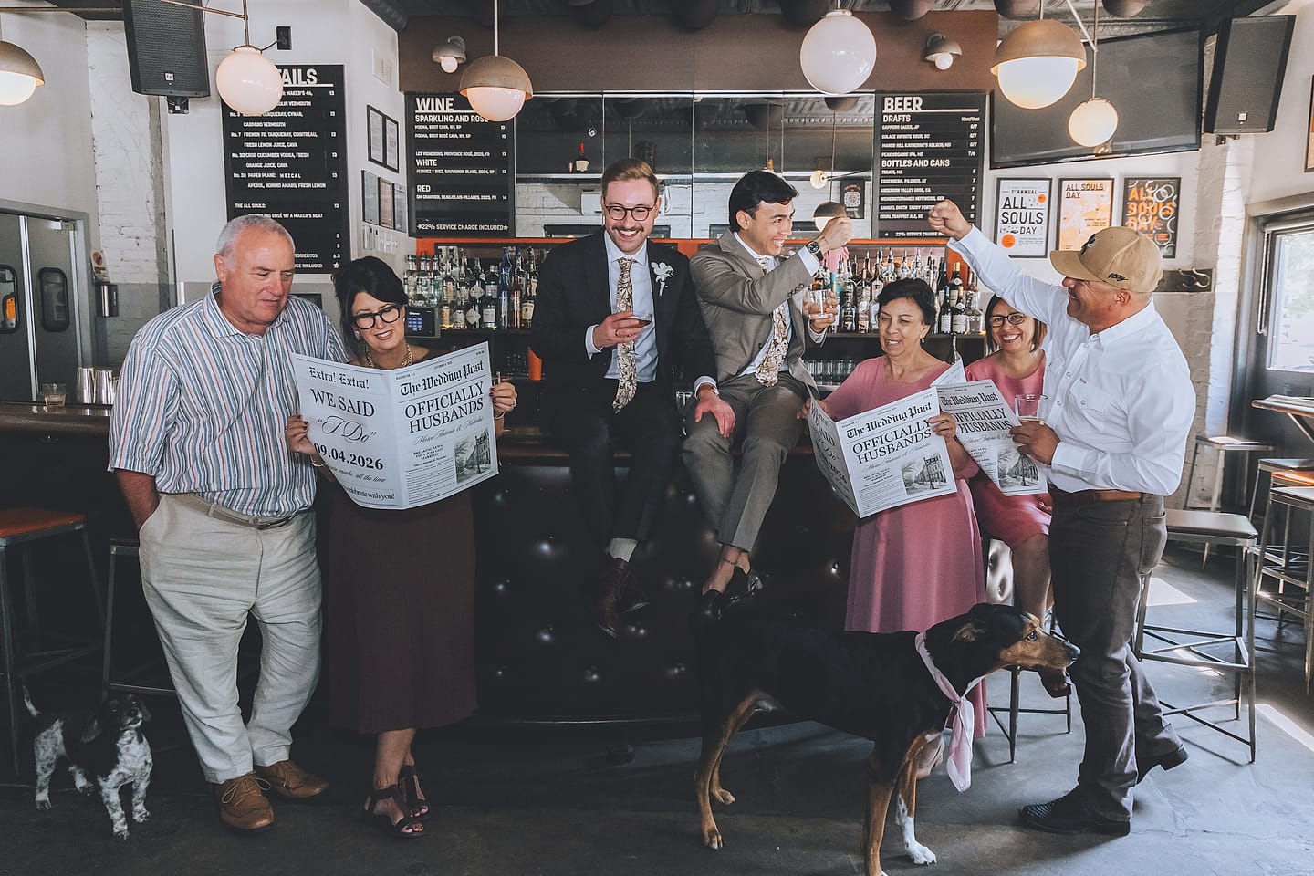 Marco and Nick celebrate with family and friends at All Souls bar in Washington, D.C., one groom perched on the bar