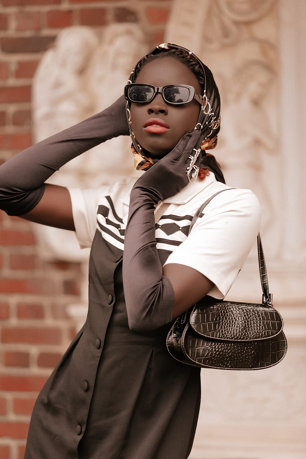 A joyful graduate in sunglasses and a kente stole